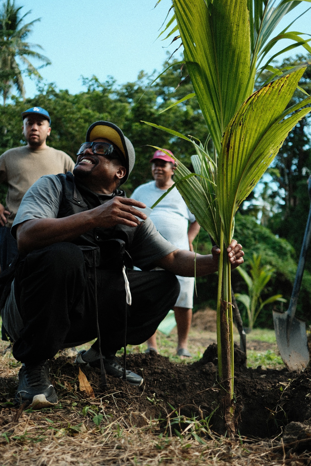 Apl planting a coconut palm in Brooke's Point.